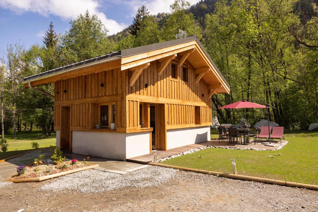 ein kleines Haus mit einem Tisch und einer Terrasse in der Unterkunft Chalet Pierre d Anatase in Saint-Gervais-les-Bains