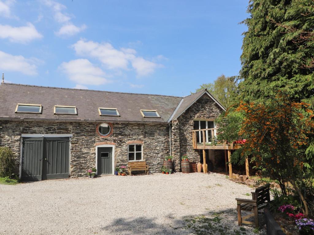 a stone house with a large driveway in front of it at The Coach House in Llangollen
