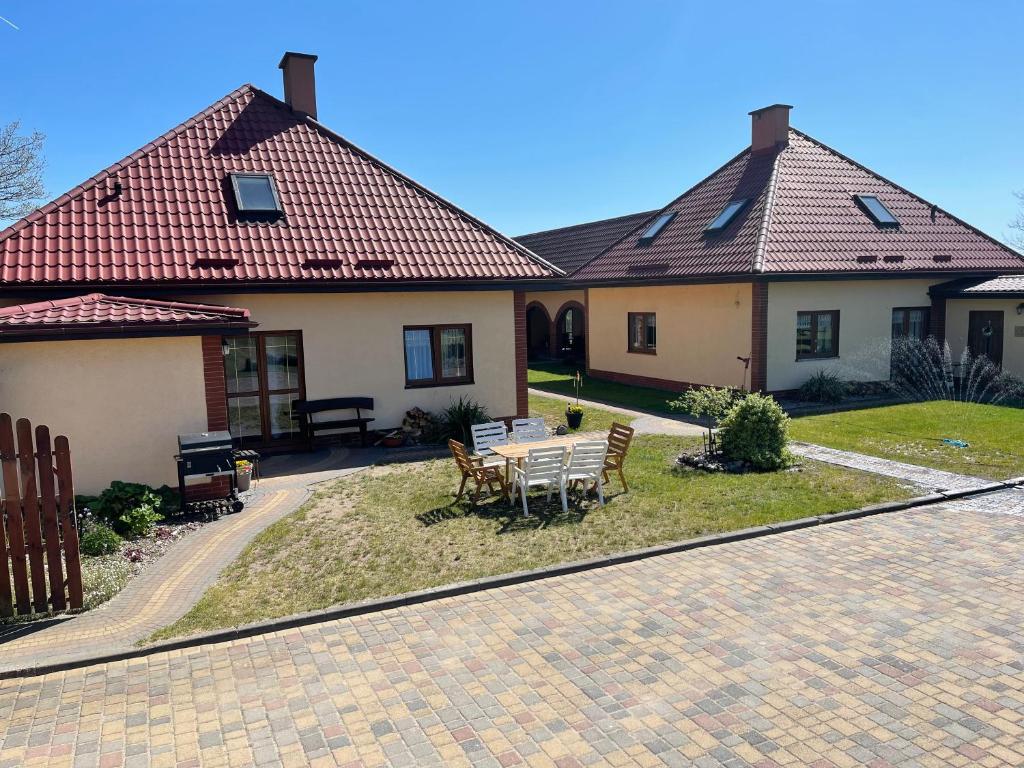 dom ze stołem i krzesłami na dziedzińcu w obiekcie Promienna chatka w mieście Miłomłyn