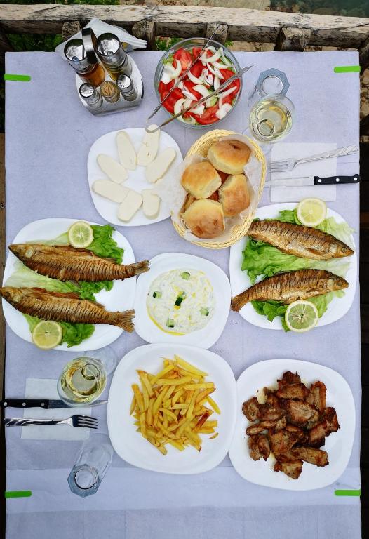 a table with many plates of food on it at Riverside Komani Lake in Koman