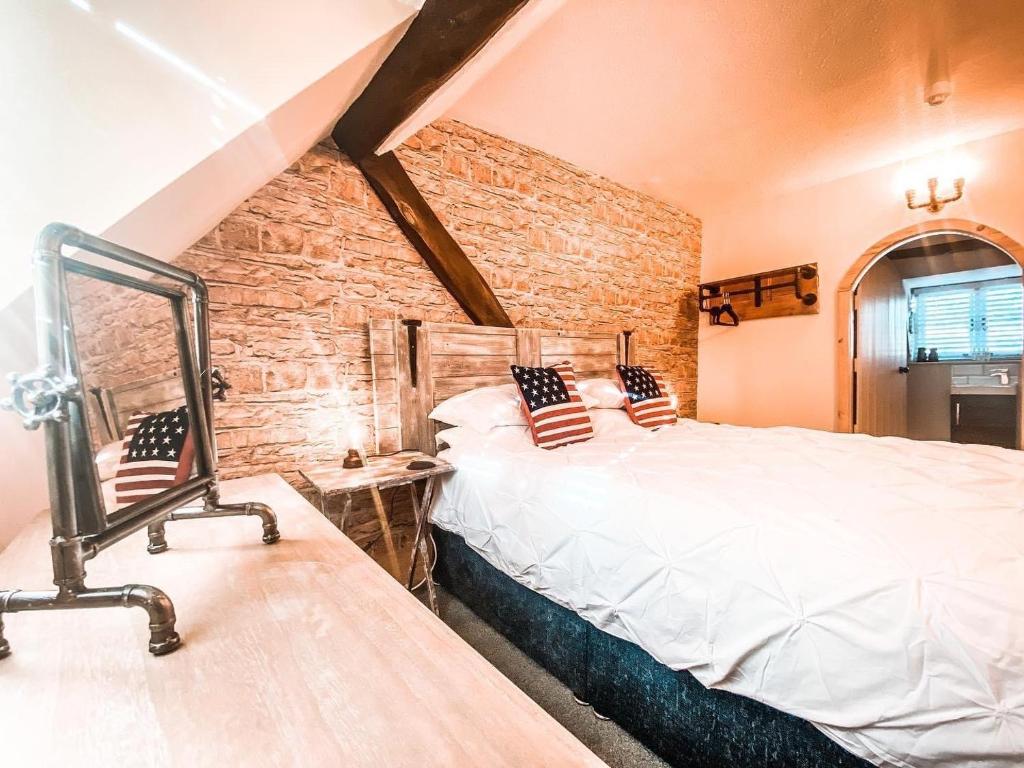 um quarto com uma cama e uma parede de tijolos em The Loft at Riverside Suites Bridgnorth em Bridgnorth