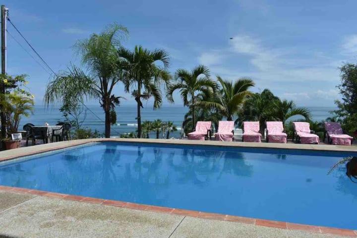 a swimming pool with chairs and the ocean in the background at Relax en Aguaclara, su Castillo de Arena soñado! in Ballenita