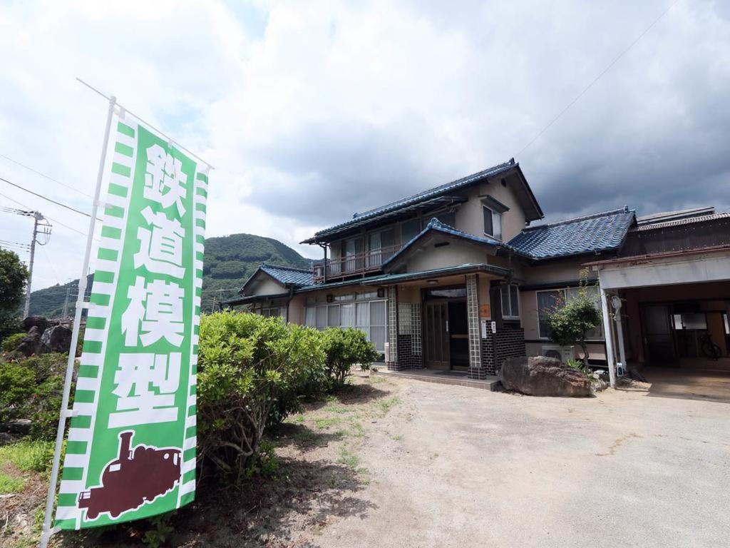 a house with a sign in front of it at Tetsu no YA Guesthouse for Railfans in Fuefuki