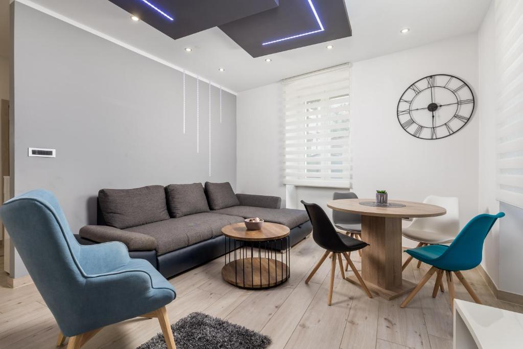 a living room with a couch and two tables and chairs at Rijeka Old Town Apartment in Rijeka