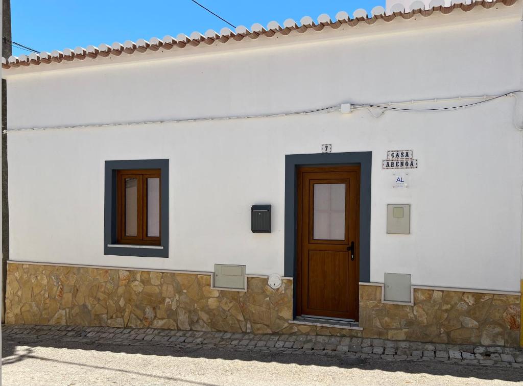 un edificio blanco con una puerta y dos ventanas en Casa Arenga en Almádena