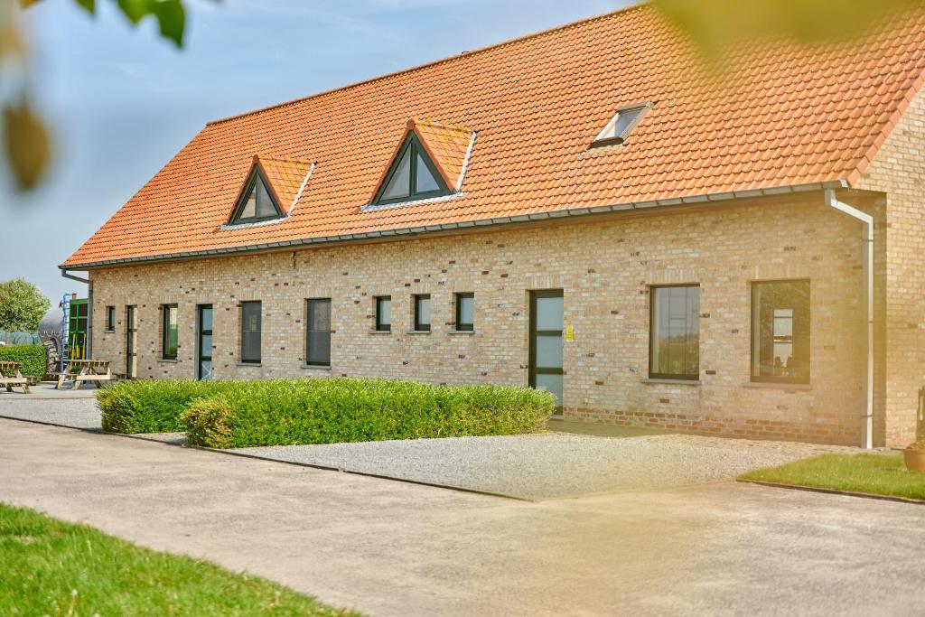 a large brick building with an orange roof at B&B Abdeshof in Middelkerke