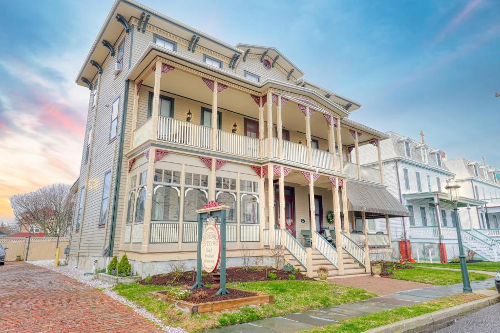 une grande maison avec un panneau en face de celle-ci dans l'établissement Bedford Inn, à Cape May