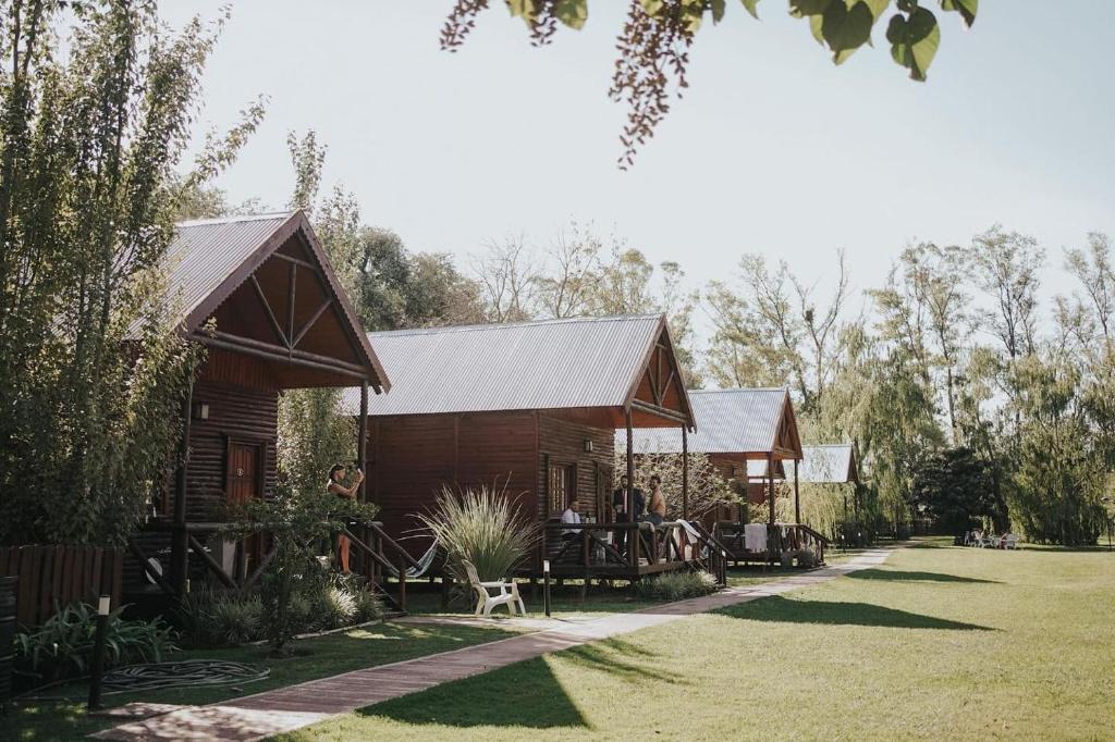 a log cabin with a porch and a yard at Fratelli Cabañas-Apart in Rosario