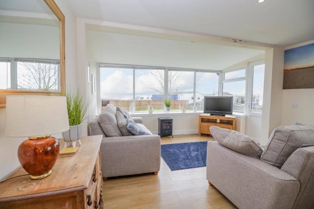 a living room with two couches and a tv at The Wigwam in Dumfries