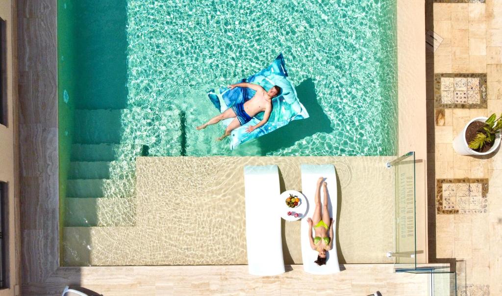 een man zwemmend in een zwembad in een zwembad bij Hotel Baglio Di Scopello in Scopello