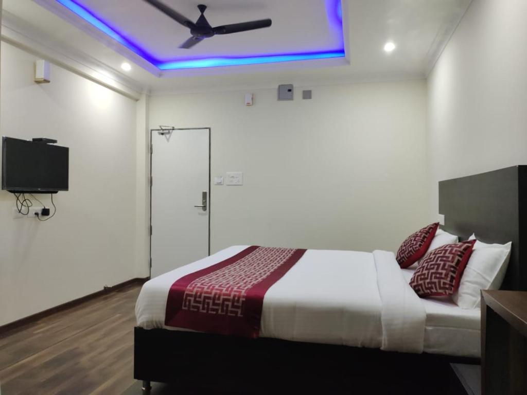 a bedroom with a bed with a ceiling fan at Venster Residency in Chennai