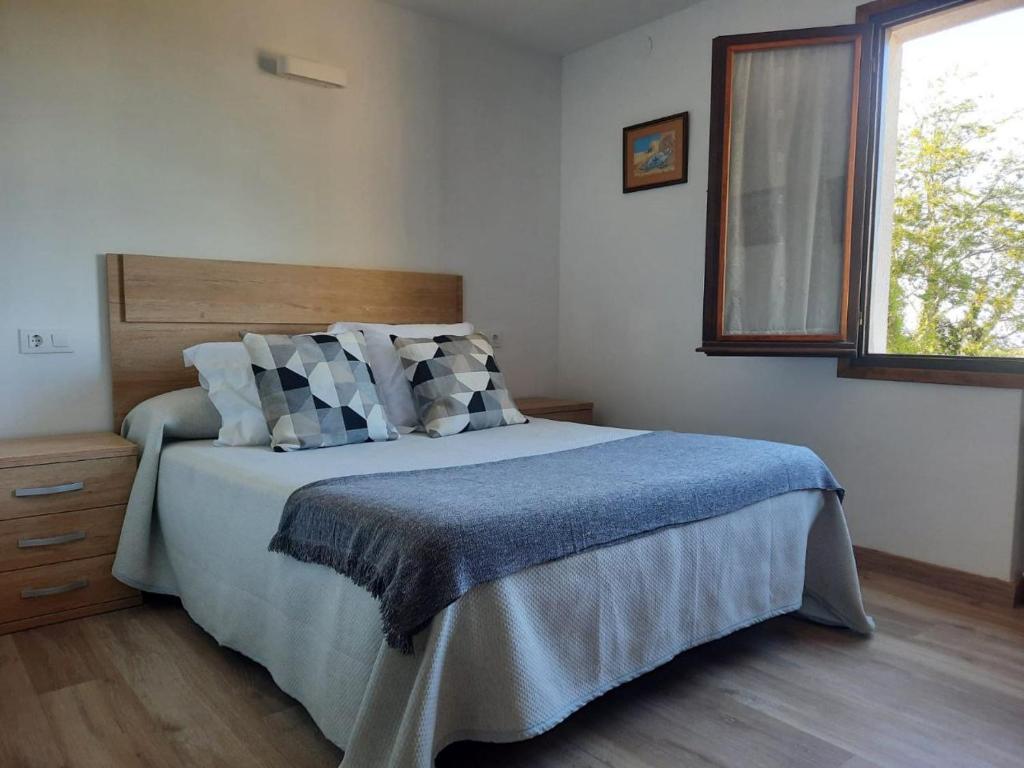 sypialnia z łóżkiem z niebieskim kocem i oknem w obiekcie Hospedaje La Espina de Pechon w mieście Pechón