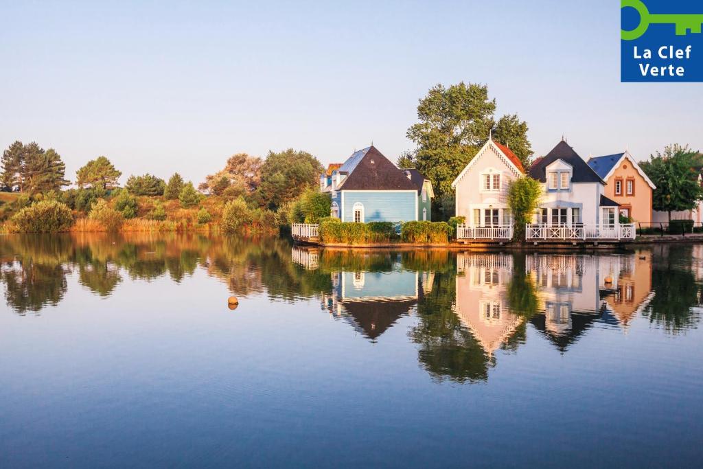 un grupo de casas sentadas junto a un lago en Village Pierre & Vacances Belle Dune en Fort-Mahon-Plage