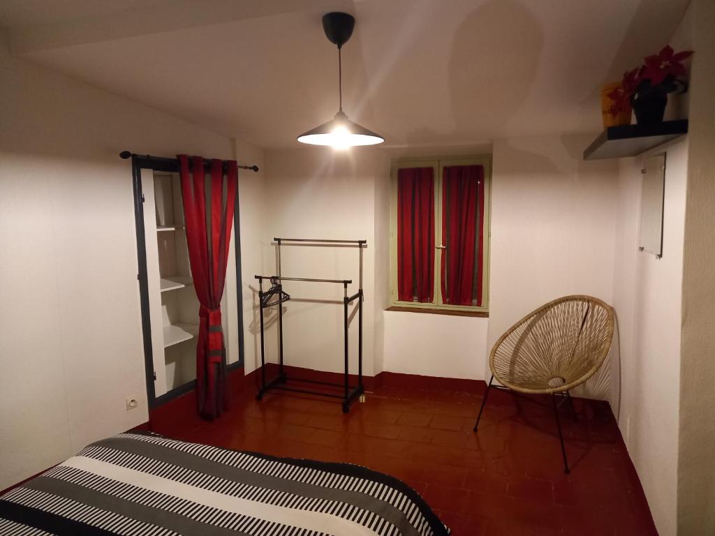 a bedroom with a bed and a chair and a window at Le Midi 2 in Trèbes