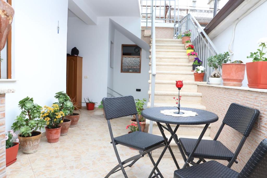 stół i krzesła na balkonie z doniczkami w obiekcie Downtown Apartment 2 w mieście Berat