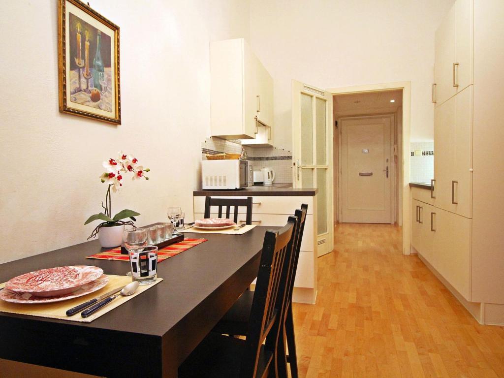 - une cuisine avec une table et des chaises noires dans la chambre dans l'établissement Apartment Judenplatz by Interhome, à Vienne
