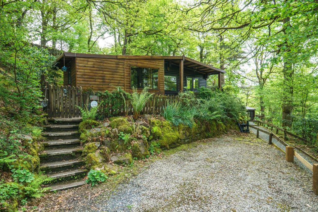 a log cabin in the woods with stairs leading to it at Dock Tarn Lodge in Ambleside