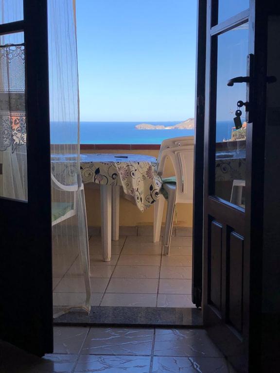 una puerta abierta a un balcón con vistas al océano en Aria Dorata, en Torre dei Corsari