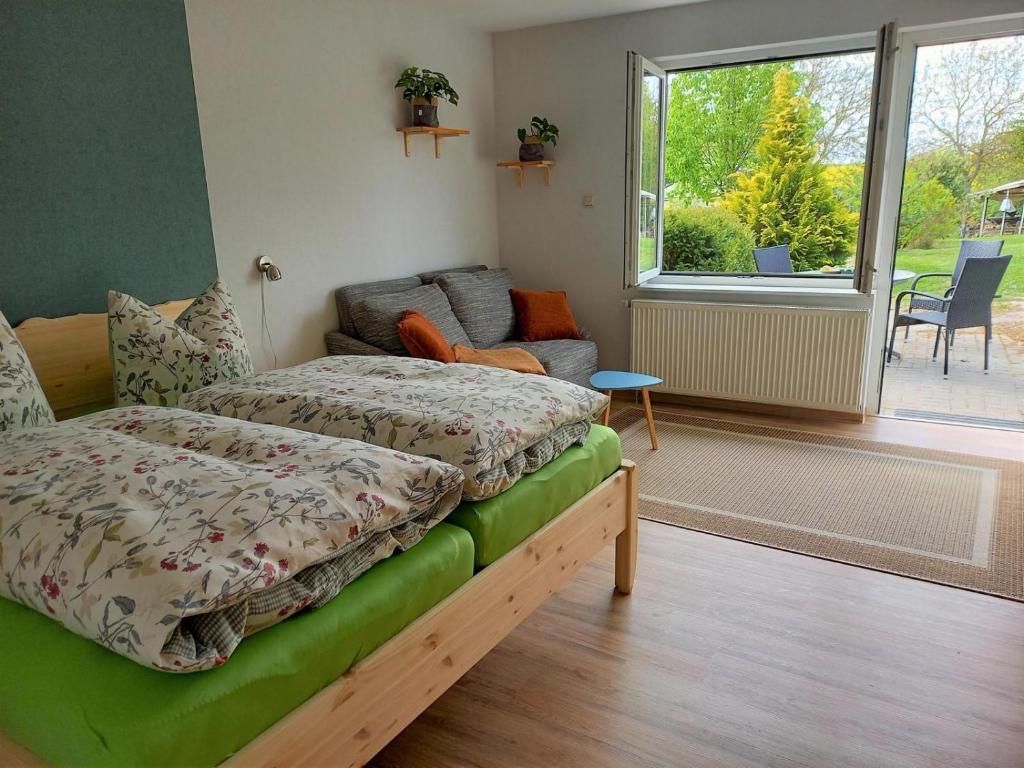 a bedroom with a bed and a couch and a window at Ferienwohnung Emil's Kuhwiese in Breitenbach