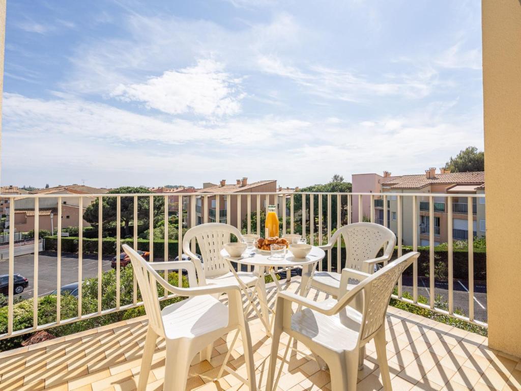 un patio avec une table et des chaises sur un balcon dans l'établissement Studio Hameau de Pech I-2 by Interhome, au Cap d'Agde