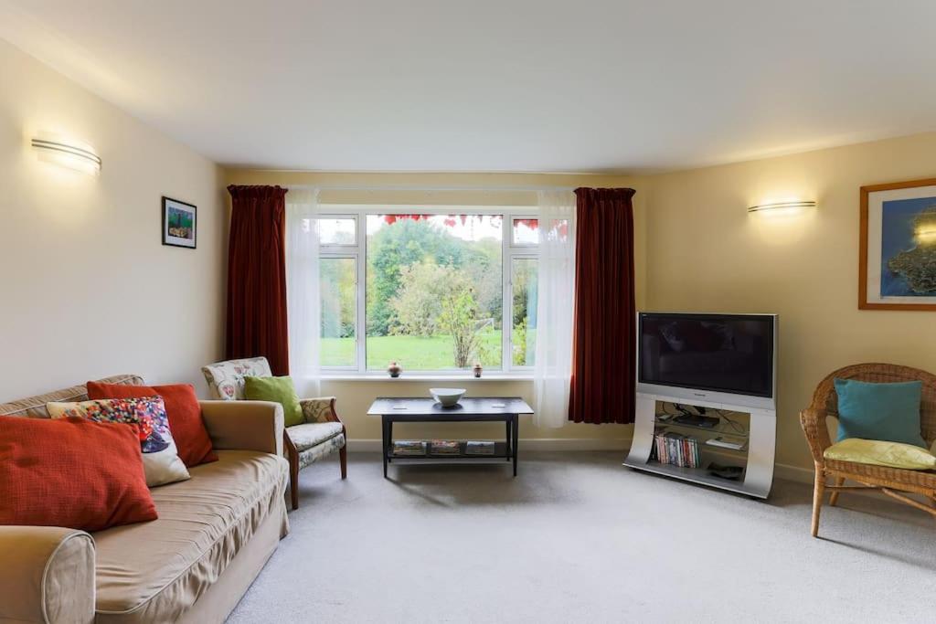 a living room with a couch and a tv at Truro apartment in a stunning quiet location in Truro