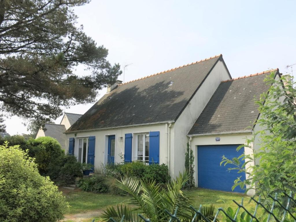 a white and blue house with a blue garage at Holiday Home Monteno by Interhome in Arzon