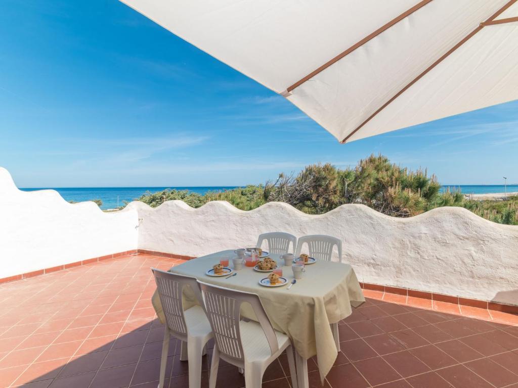 una mesa y sillas en un patio con vistas al océano en Apartment Villa Selena by Interhome, en Codaruina