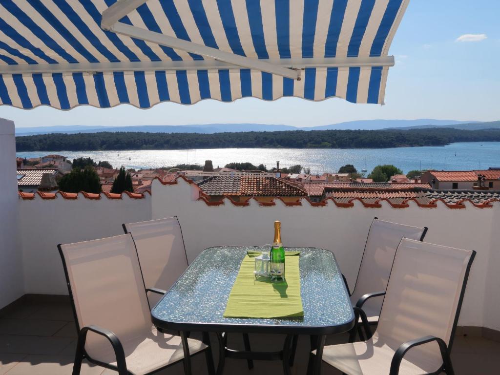 stół i krzesła na balkonie z widokiem na wodę w obiekcie Apartment Barbara-2 by Interhome w mieście Punat
