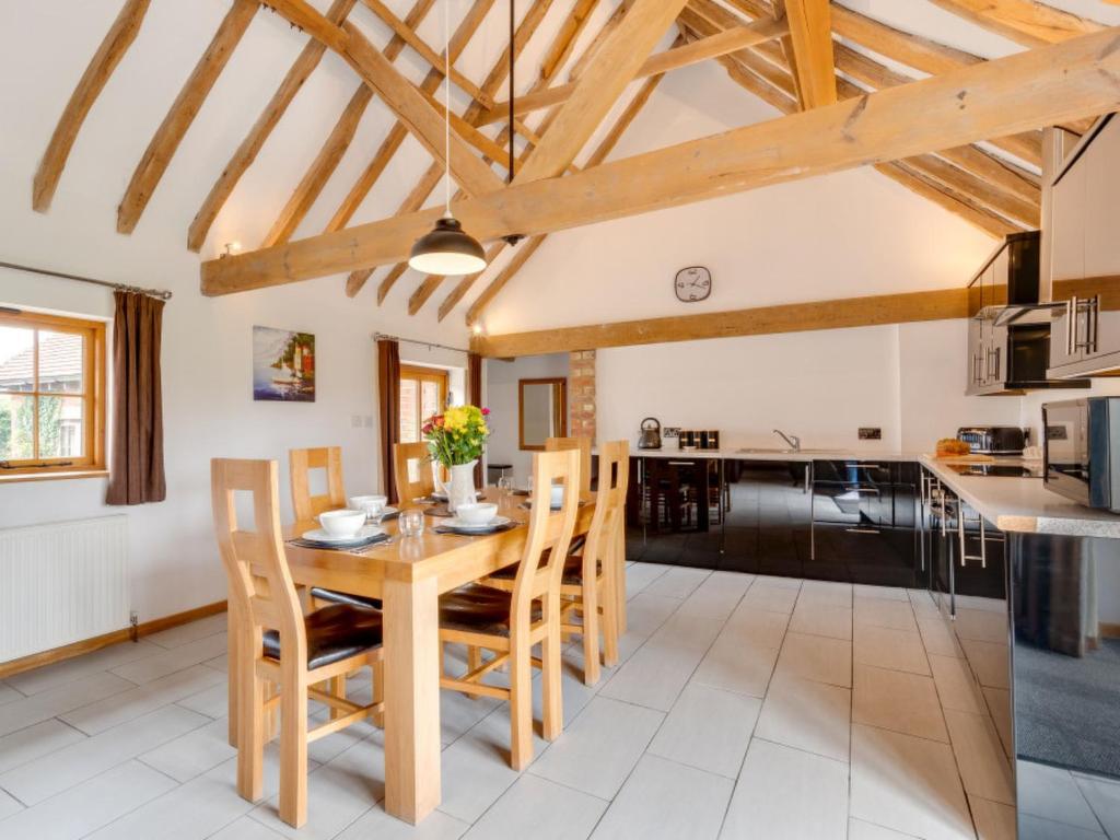 a kitchen and dining room with a wooden table and chairs at Holiday Home Church Farm by Interhome in Brede