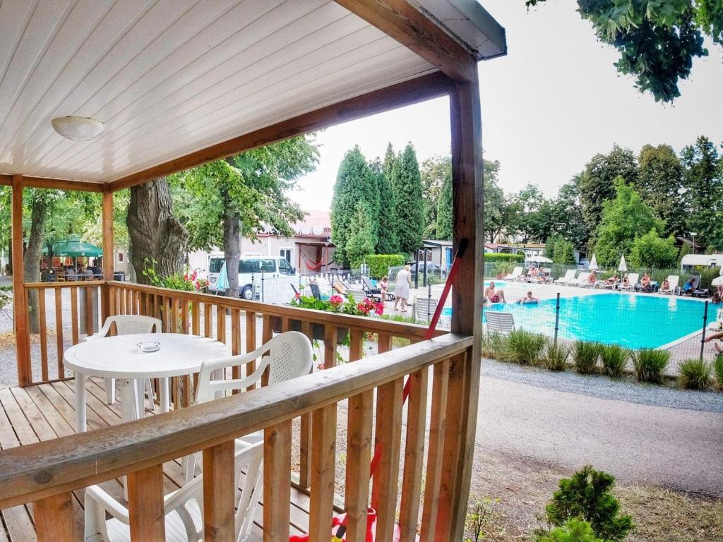 drewniany taras ze stołem i krzesłami oraz basenem w obiekcie Holiday Home Sunset Terrace by Interhome w Pradze