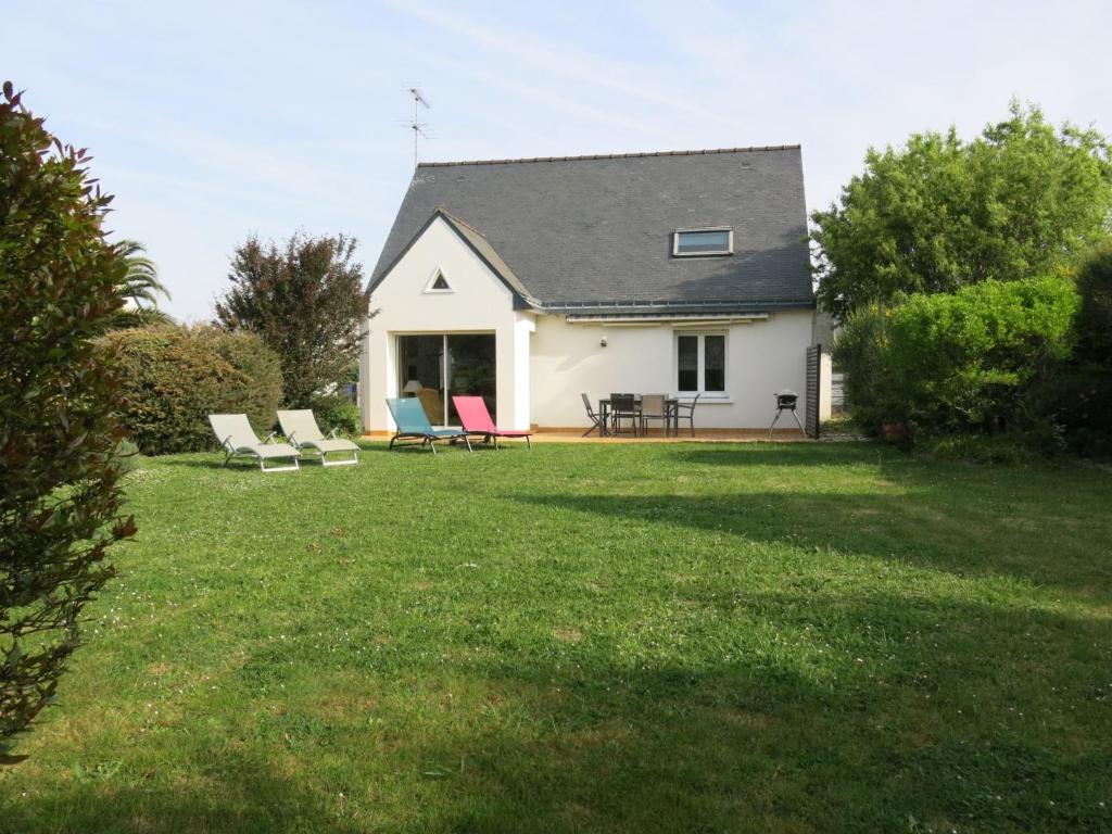 a white house with chairs on a yard at Holiday Home Les Embruns by Interhome in Sarzeau
