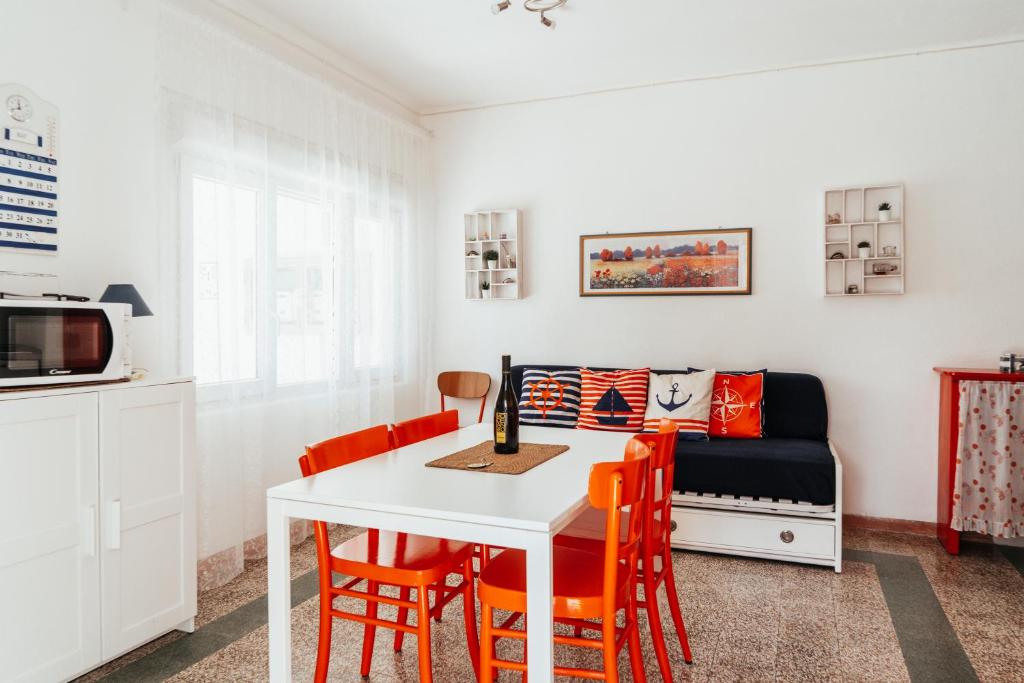 comedor con mesa, sillas y sofá en Casa Zanelli, en Lignano Sabbiadoro