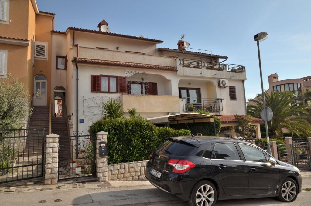 a black car parked in front of a house at Apartments Pula in Pula