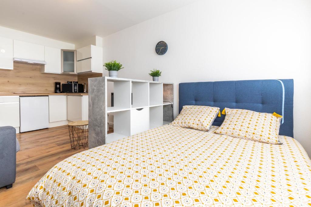 a bedroom with a bed with a blue headboard at La fée verte in Pontarlier