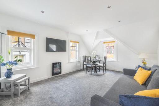 a living room with a couch and a table at Coast View Luxury Apartment in Lyme Regis