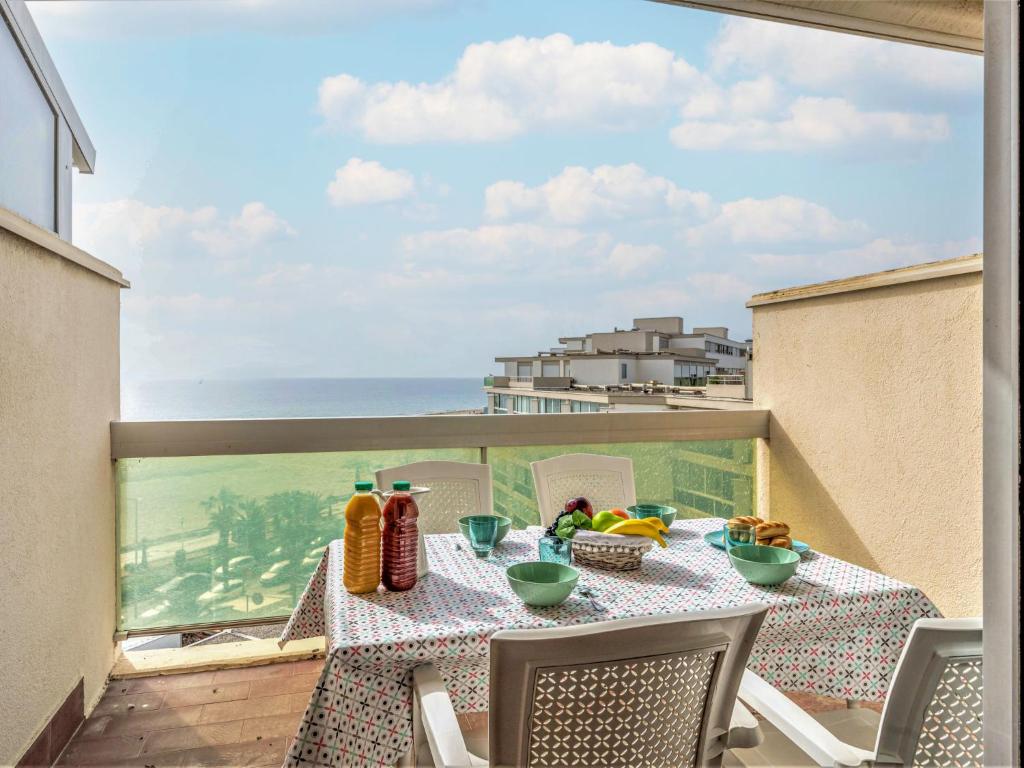 a table on a balcony with a view of the ocean at Apartment Les Jardins de la Plage by Interhome in Canet-en-Roussillon