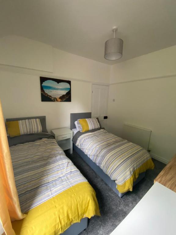 a bedroom with two beds and a pendant light at Ifan cottage - two bedroom cottage in Meliden