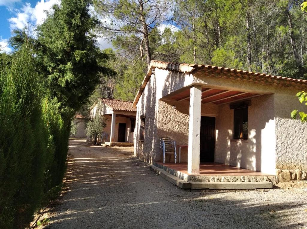 une maison avec une terrasse couverte sur le côté d'une route dans l'établissement Casas Rurales Hoya Calvete, à Yeste