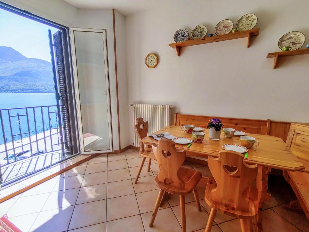 a dining room with a table and a large window at Apartment Relax by Interhome in Gravedona