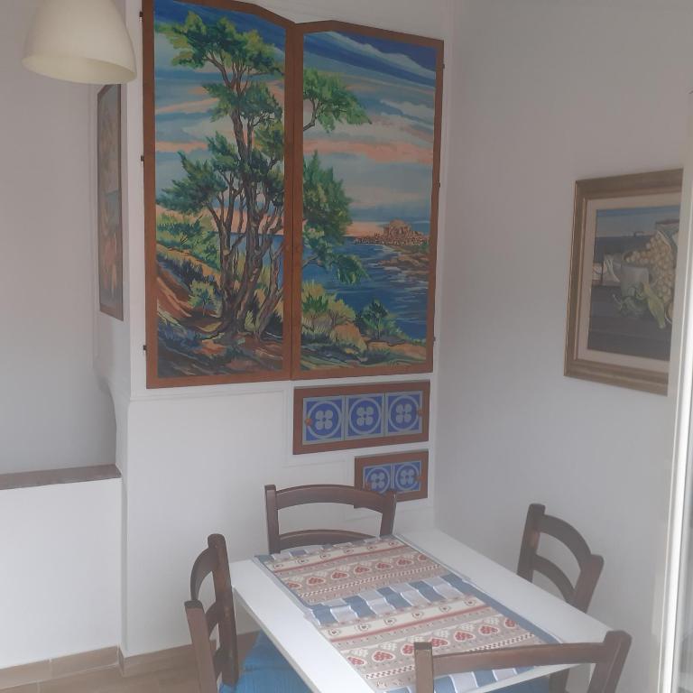 een tafel en stoelen in een kamer met een schilderij aan de muur bij A casa dell'artista in Cefalù