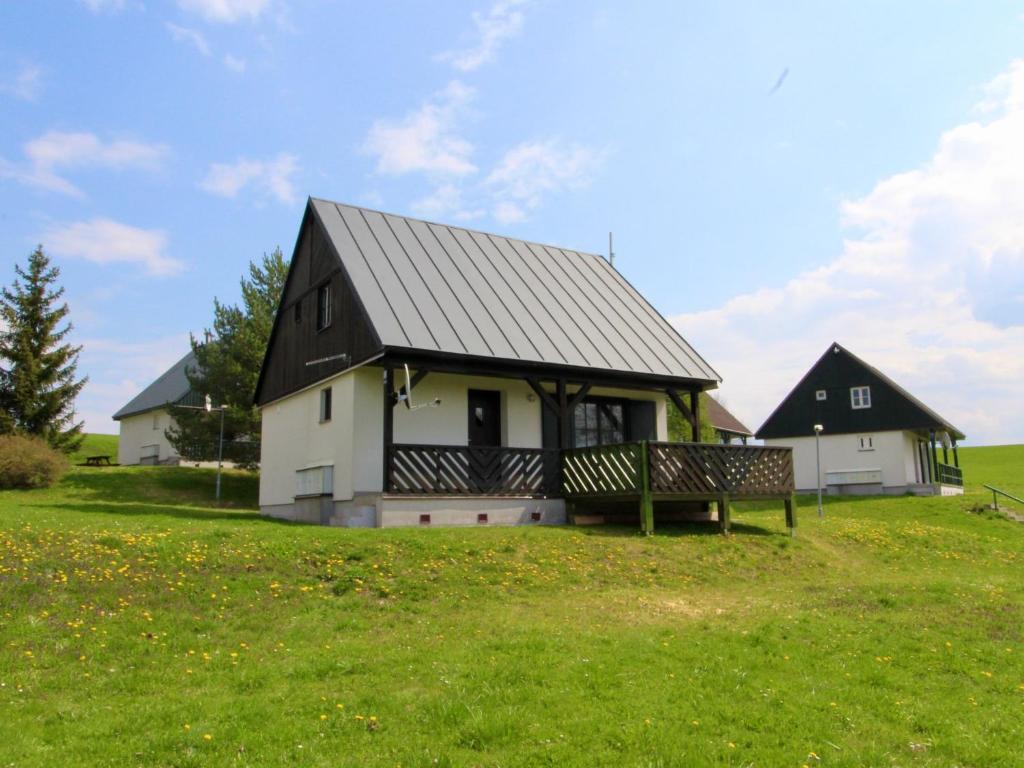 uma casa a preto e branco com um banco num campo em Holiday Home Holiday Hill 55 by Interhome em Čistá