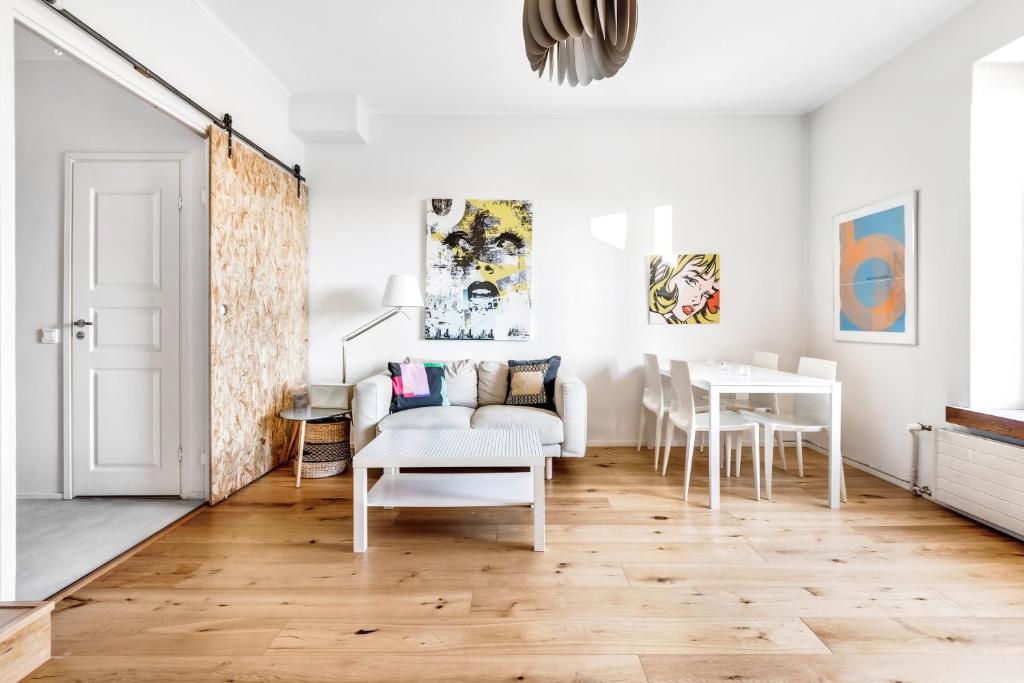 un soggiorno con divano bianco e tavolo di WeHost 1BR Scandinavian Style Top Floor Apartment a Helsinki