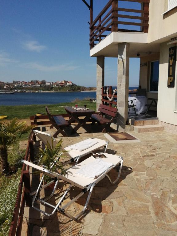 a group of lounge chairs on a patio near the water at VIP in Ahtopol