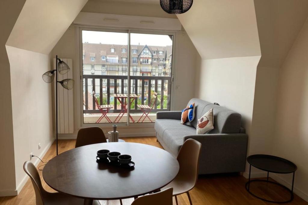 a living room with a table and a couch at Nice 41 M With Balcony Near The Beach in Deauville