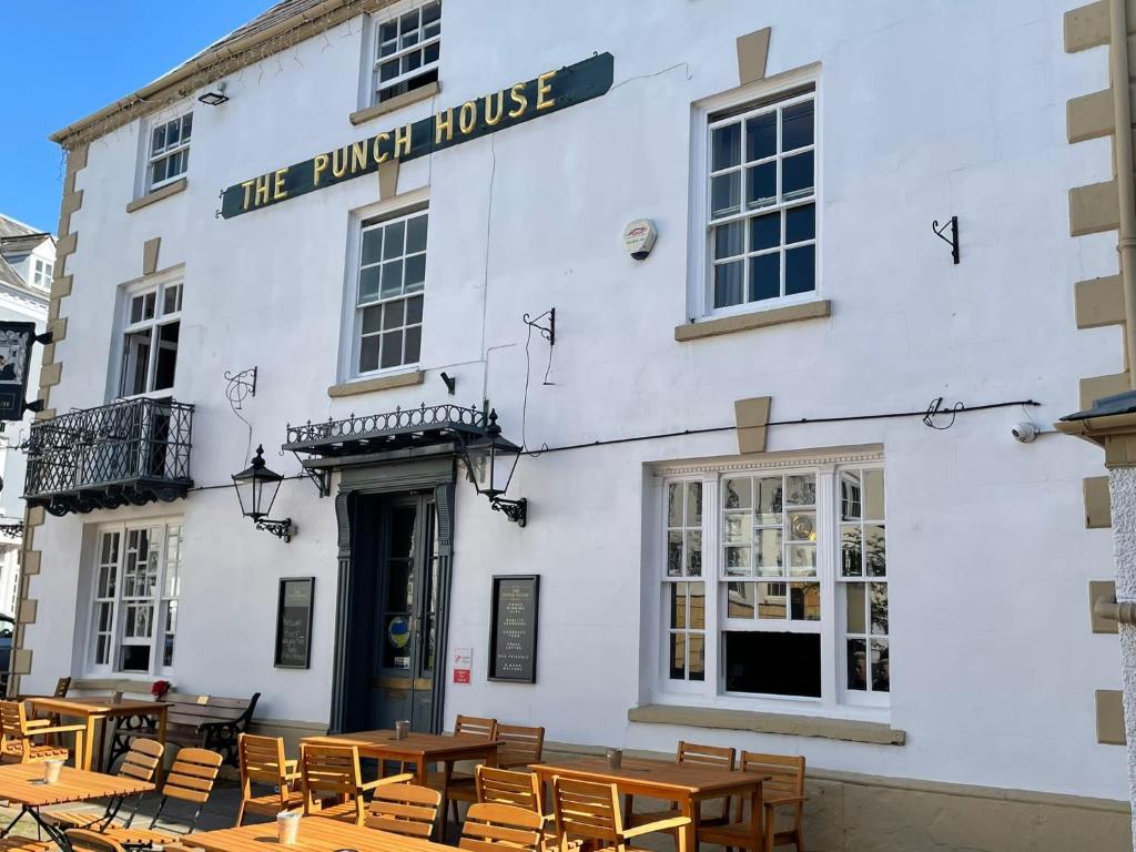 a white building with tables and chairs in front of it at Punch House Monmouth in Monmouth