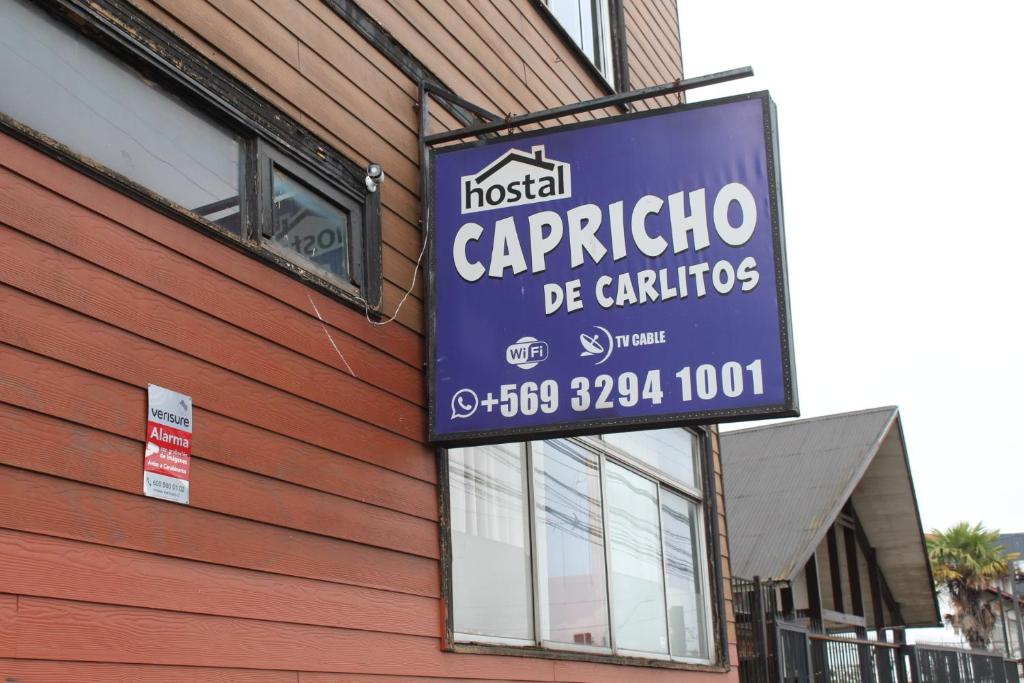 una señal para un restaurante al lado de un edificio en Hostal Capricho de Carlitos, en Valdivia