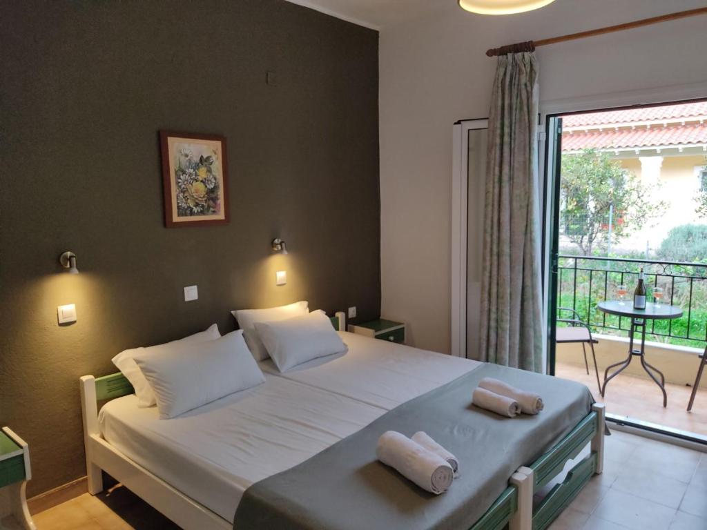 una camera da letto con un letto e due asciugamani di Oliveland Apartments a Kávos