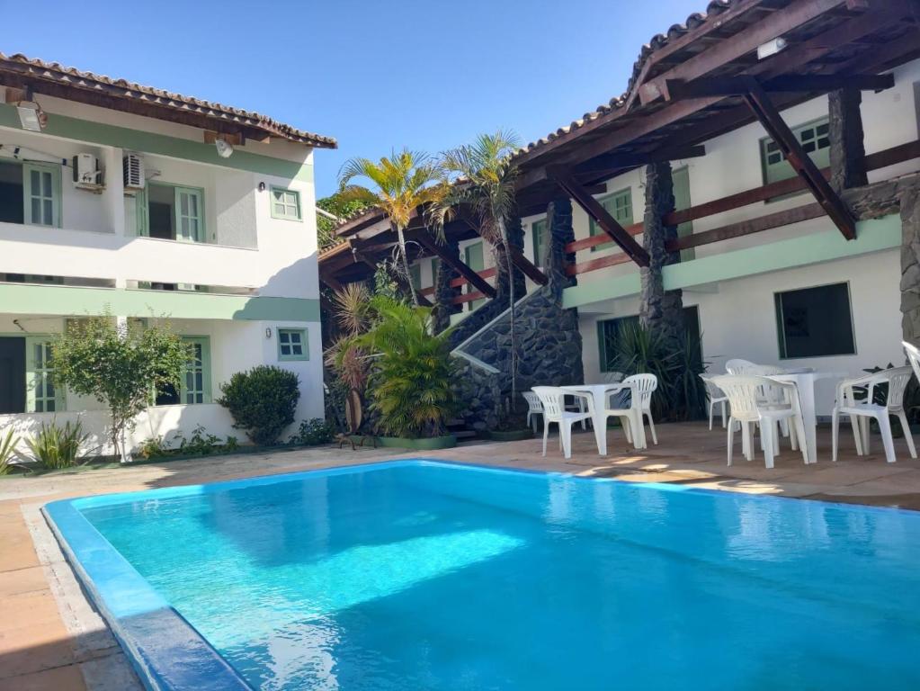 a villa with a swimming pool and a house at Hotel Porto Verde -JG in Porto Seguro