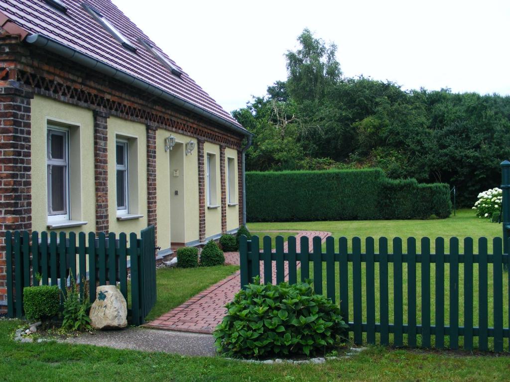 a fence in front of a house with a yard at Ferienwohnungen „Villa Havelblick“ in Rathenow