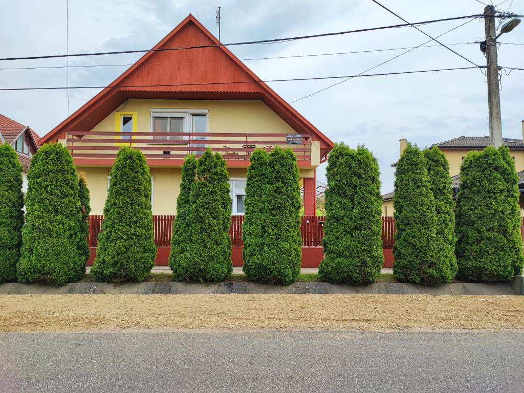 a house with a red roof and a bunch of bushes at Szaffi apartman in Hajdúszoboszló